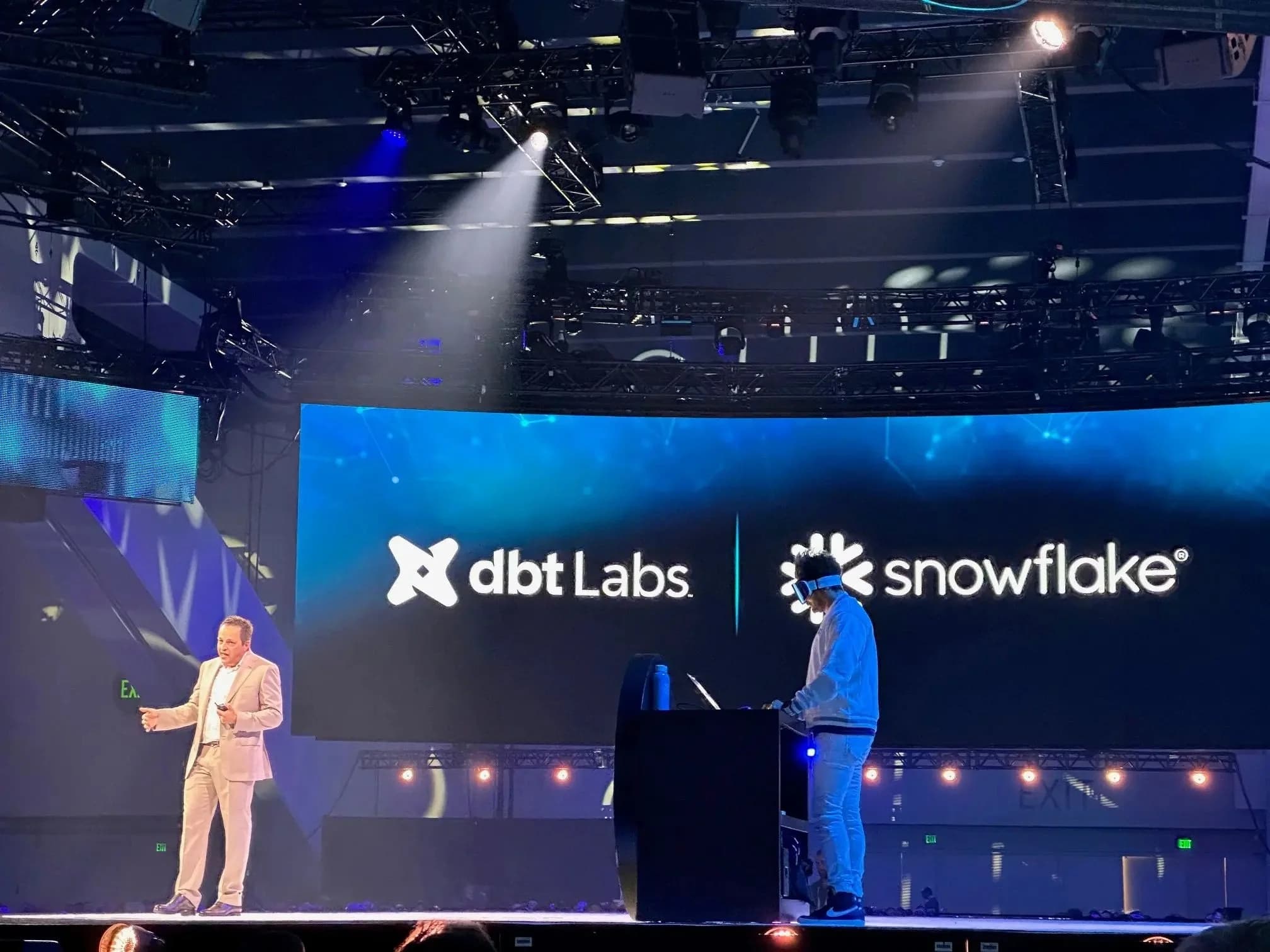 Presenters on the Snowflake Summit keynote stage with dbt Labs and Snowflake logos